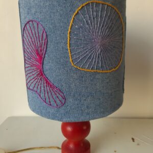Blauw geborduurde lampenkap op rode lampvoet